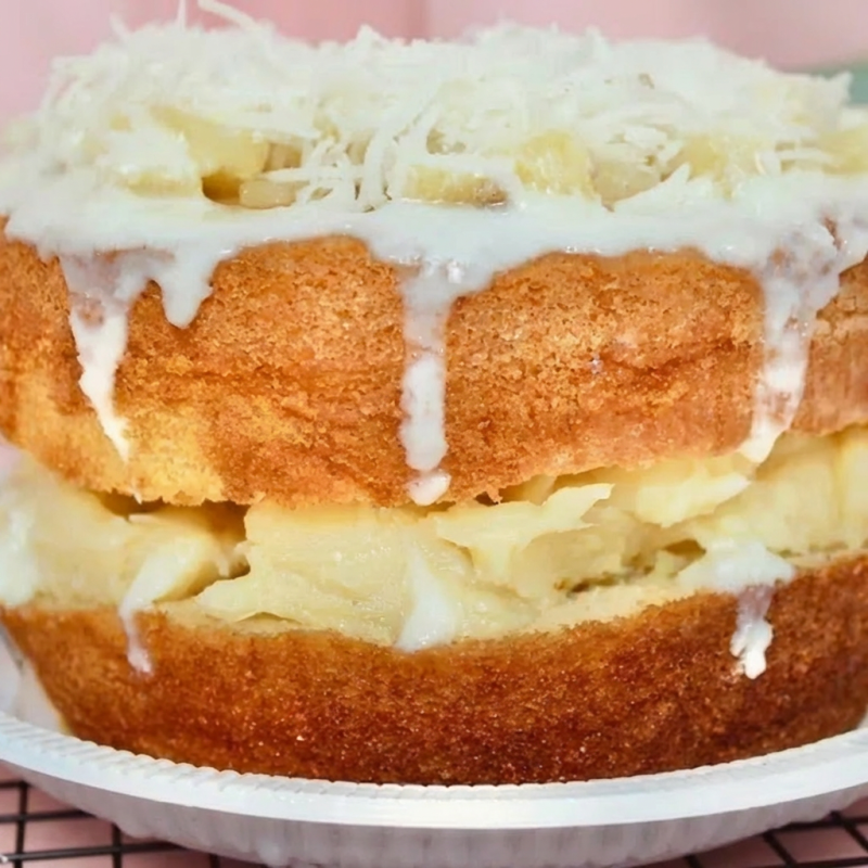 Massa branca 100% caseiro com recheio de beijinho, com abacaxi cozido picado e bastante calda de coco artesanal. serve até 15 fatias