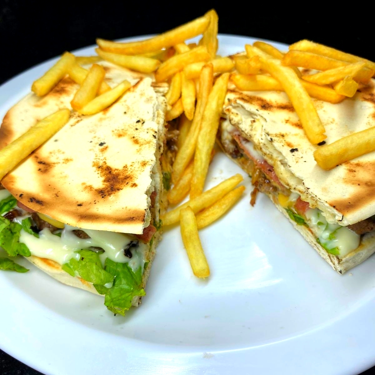 Pão sírio, frango, queijo, presunto,cebola caramelizada, to.mate, alface e batata.
