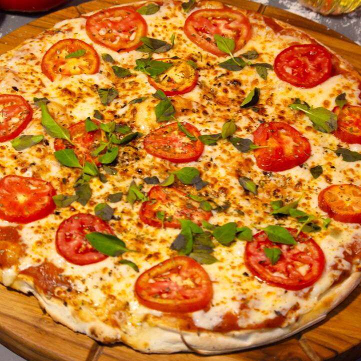 Pizza saborosa composta por: Molho de Tomate, queijo mussarela, tomate em rodelas, manjericão e Orégano.