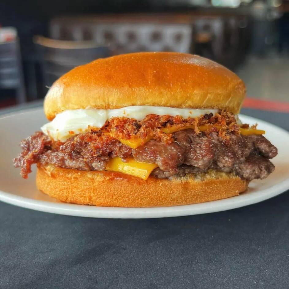 Pão brioche preparado com 2 carnes smash (60g cada), queijo cheddar em fatia, catupiry original e bacon em cubos.