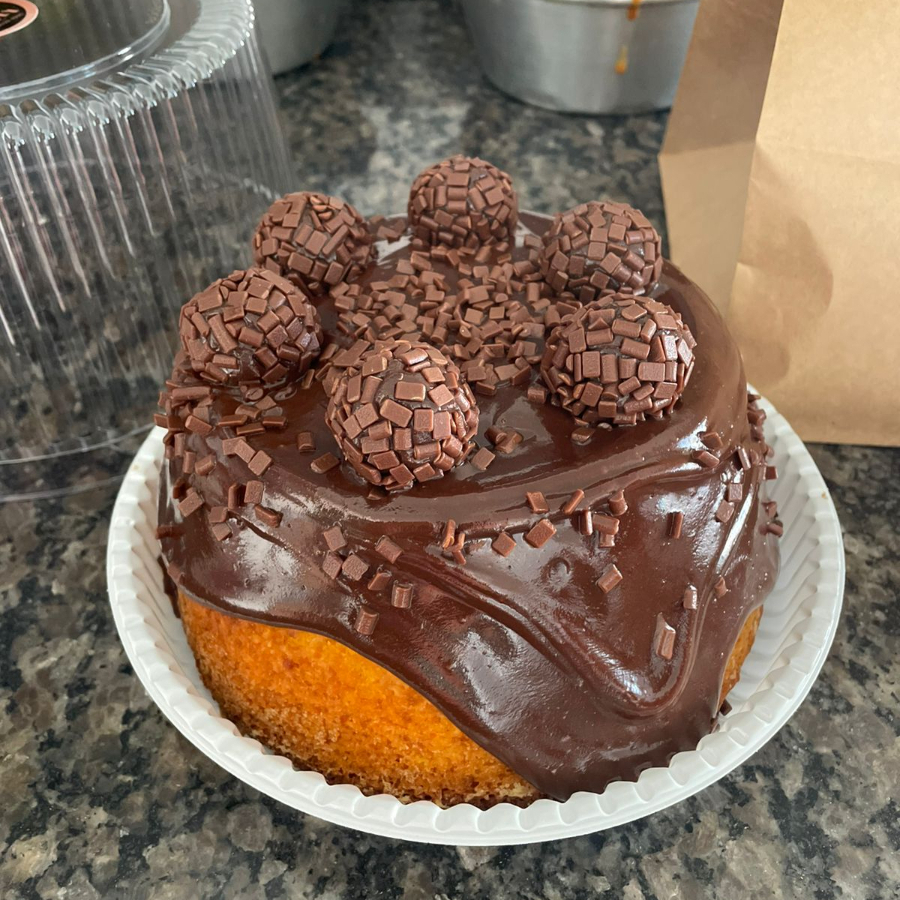 Deliciosa massa fofa de cenoura, cheio e coberto com cremoso de chocolate meio amargo e finalizado com brigadeiros.