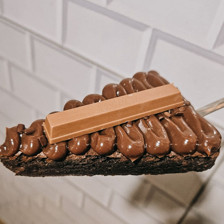 Uma deliciosa e chocolatuda fatia de brownie, cobertura de chococolate, kitkat e granulé para finalizar.