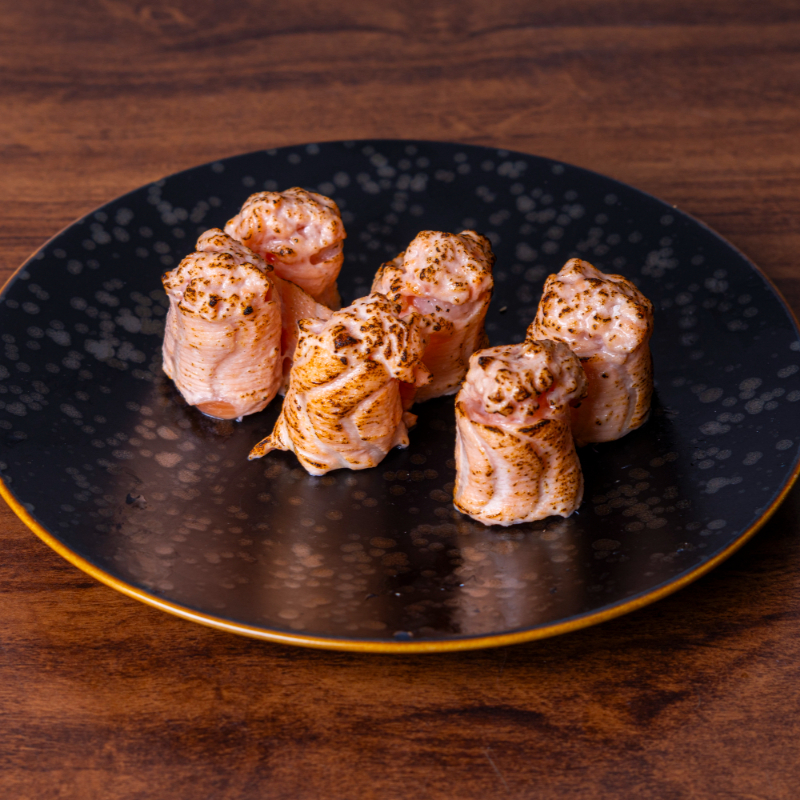 Lâmina de salmão envolto de arroz, e por cima pasta de curry e cream cheese.