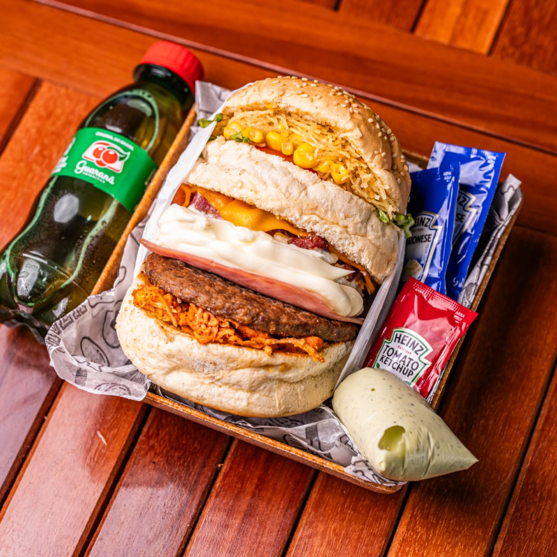 ESPECIAL BURGUER (Pão artesanal, suculenta carne bovina, queijo derretido, presunto, ovo com bacon em cubos , frango desfiado com tempero especial, catupiry ou cheddar cremoso , batata palha fina, milho verde, alface crespa e tomate fresco) Acompanha refrigerante 200ml SACHÊS DE MOLHO COBRADOS Á PARTE