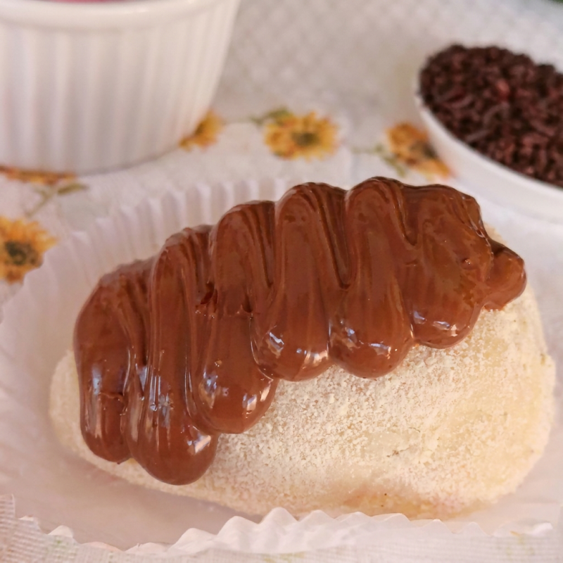 Um morango envolvido no brigadeiro de Ninho, passado no leite em pó e finalizado com Nutella Original.