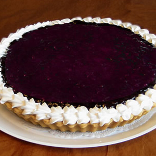 Rebanada de pay de queso con zarzamora