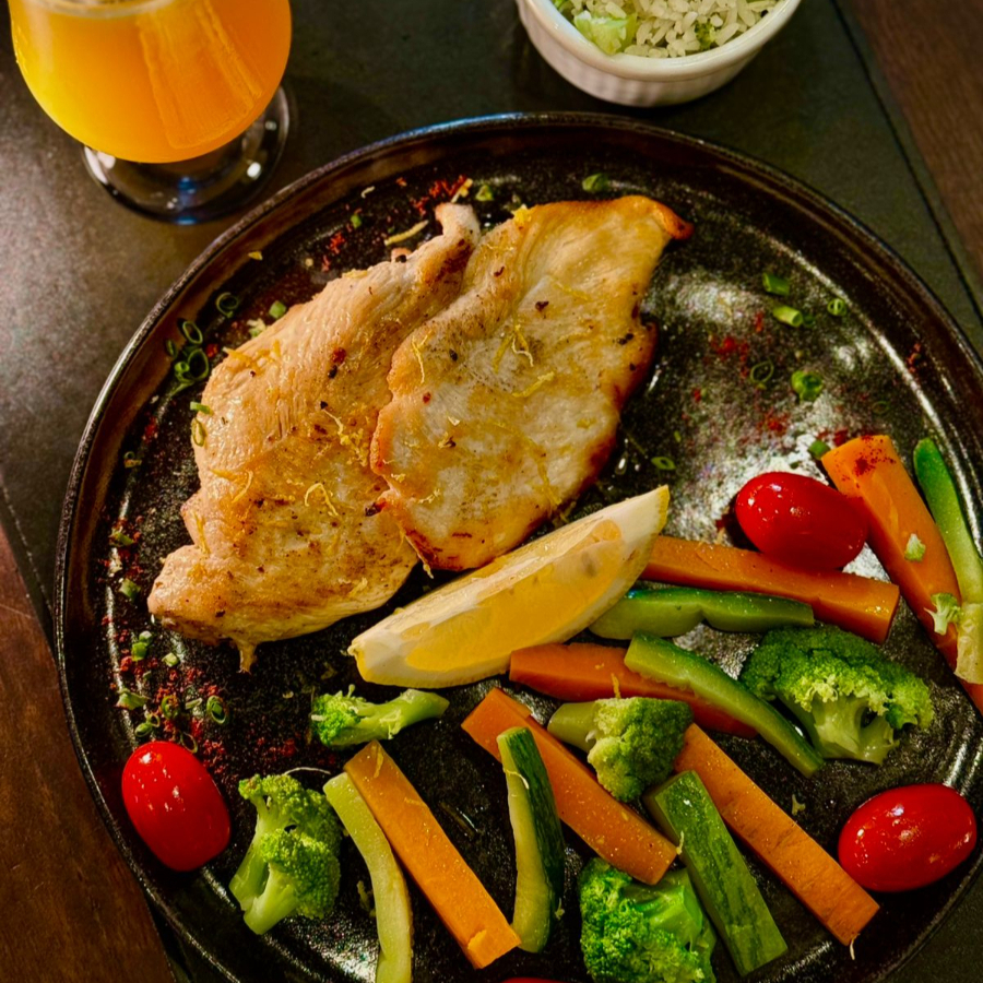 Frango dourado ao limão siciliano, acompanhado de arroz de brócolis e legumes salteados. Sabor delicado e equilíbrio perfeito.