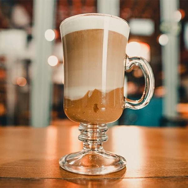 Uma dose de café espresso, calda de chocolate e leite cremoso vaporizado