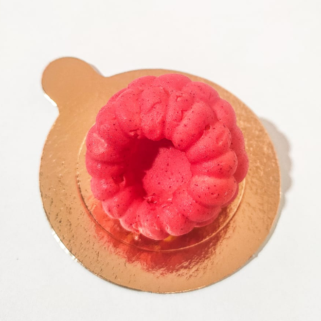 Isso não é uma framboesa! É o nosso entremet framboise, que é feito em formato de uma framboesa, cheio de sabor, combinado com a acidez das frutas, um sabor diferente de tudo que ja provou. Sendo feito com uma ganache de chocolate branco, recheado com compota cremosa de frutas vermelhas e curd de maracujá, revestido com uma finissima casquinha de chocolate.