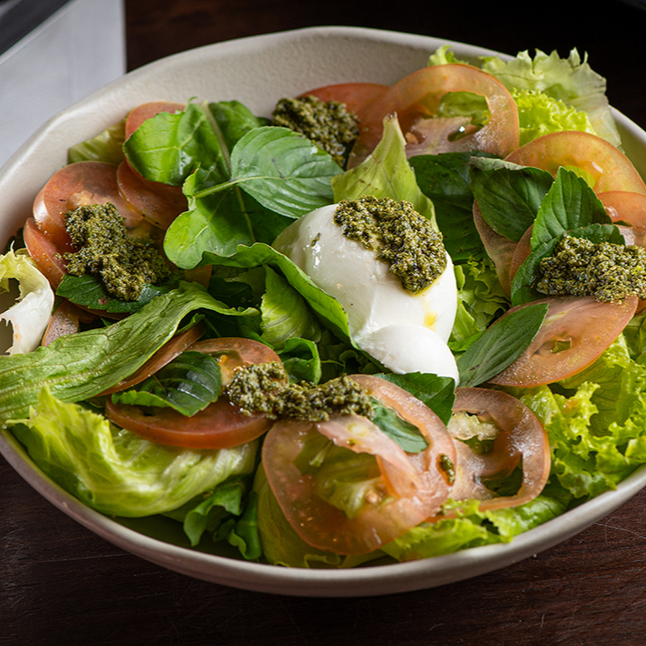Salada Caprese com tomates italianos, mozzarella de búfala e folhas frescas de manjericão. Leve, fresca e cheia de sabor.