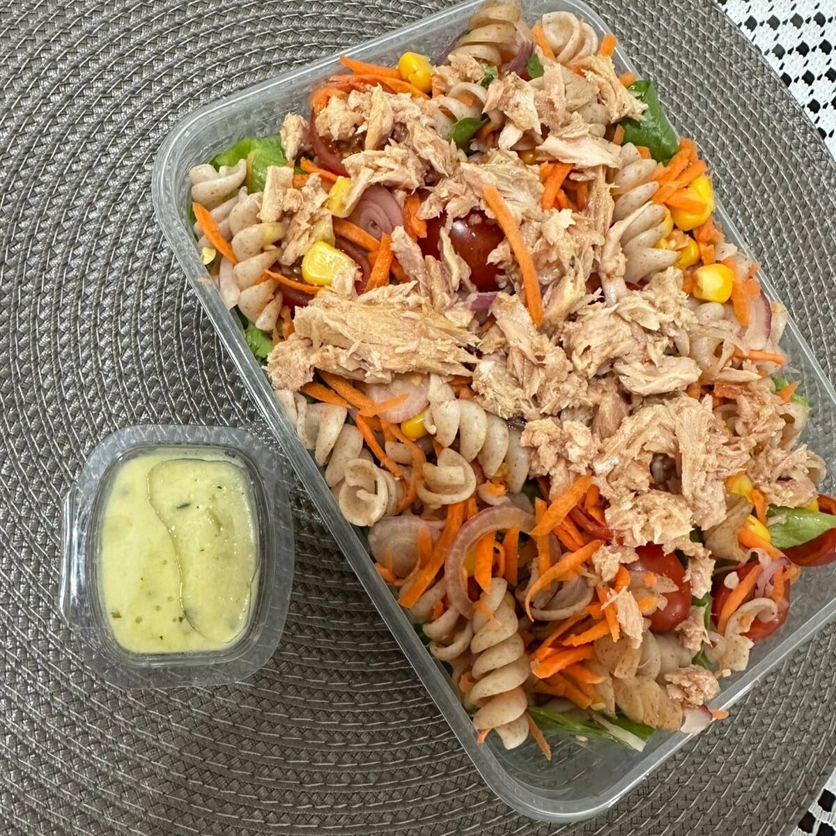 Alface, macarrão integral, tomate cereja, cebola roxa, cenoura, milho, atum. Acompanha molho