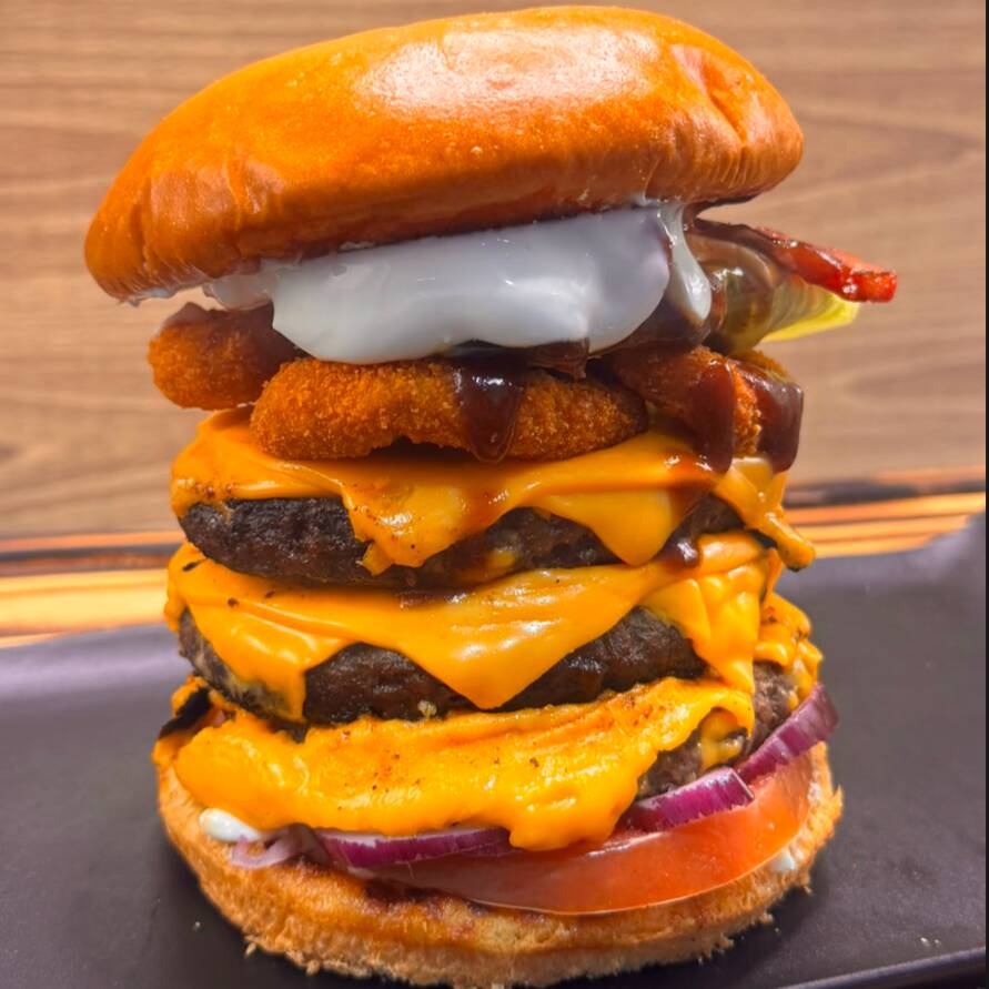 delicioso lanche especial acompanha pão de Hamburguer macio , 3 hamburgueres , Onion rings , maionese grill , cheddar fatiado , Bacon crocante , alface , tomate , cebola roxa , Molho barbecue