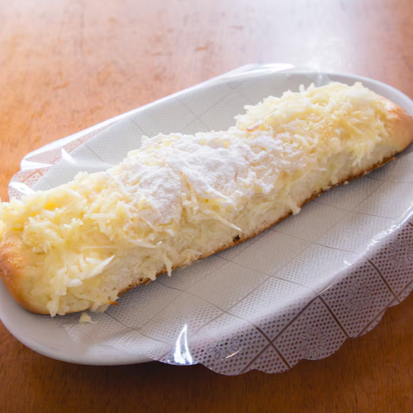 Doce tradicional preparado com massa leve e macia, coberto com generosa camada de coco ralado e açúcar de confeiteiro.