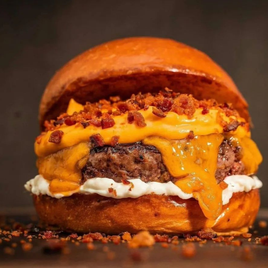 Uma combinação perfeita entre o doce e o salgado. Preparado no pão brioche macio, com hambúrguer suculento de 150g, cheddar cremoso, queijo cheddar, cebola caramelizada e a exclusiva maionese da casa, este lanche entrega uma explosão de sabor, cremosidade e suculência em cada mordida.