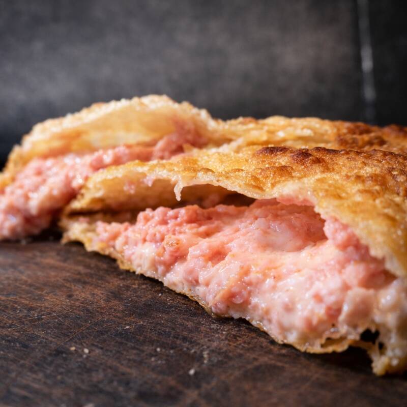 Um delicioso pastel de pizza, bem recheado com presunto perdigão e queijo mussarela acompanhado com oregano