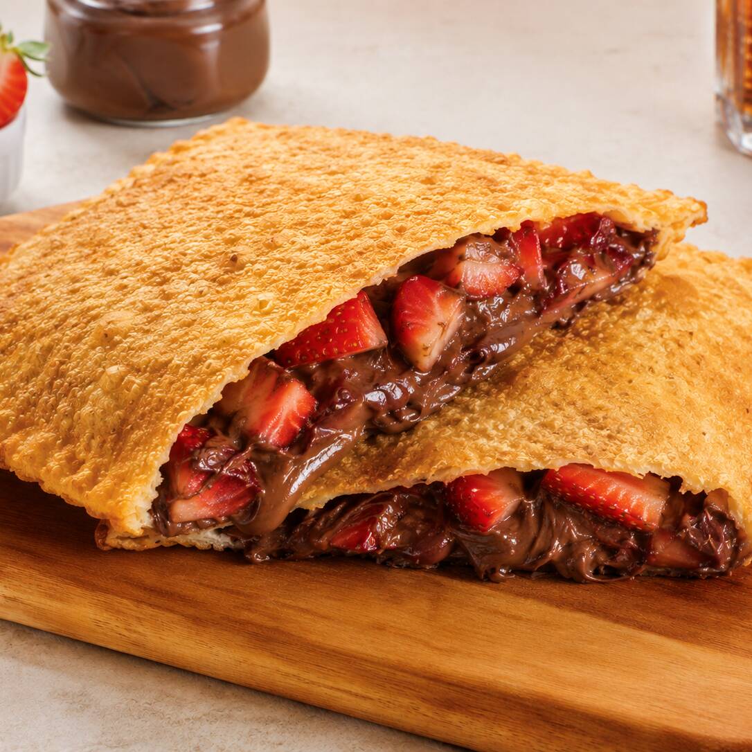 Pastel doce de 21 cm com Nutella cremosa e morango, feito na hora com massa crocante e recheio caprichado. Uma combinação clássica, deliciosa e perfeita para matar a vontade de sobremesa.