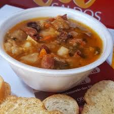 Caldo de mocotó acompanhado de feijão branco, linguiça calabresa e batata.