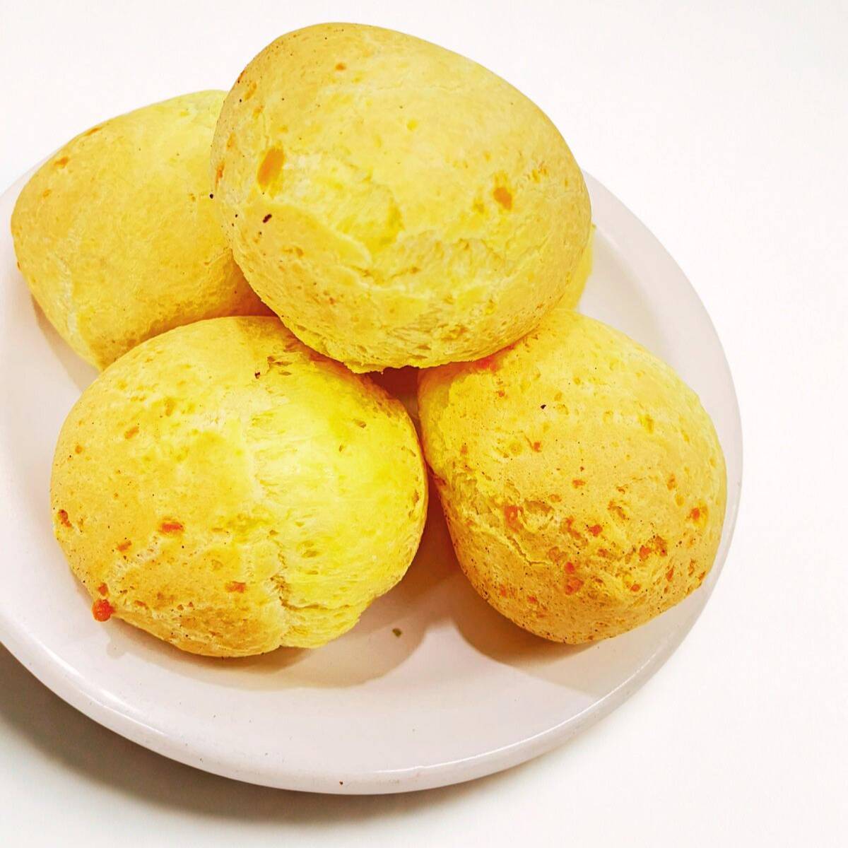 Pão de queijo crocante por fora e macio por dentro, feito com queijo Minas autêntico.