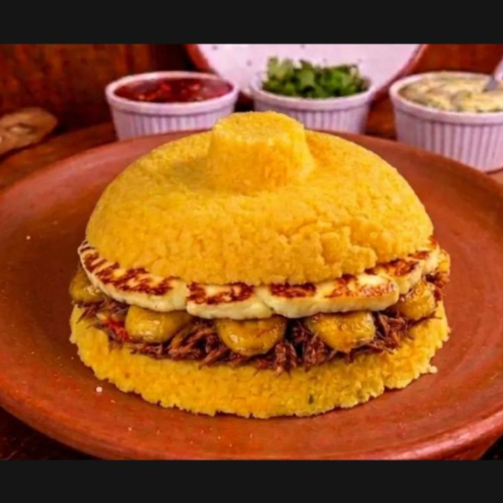 Massa de cuscuz molhadinha e fofinha recheada com queijo coalho, banana assada e carne seca desfiada e temperada com alho e cebola