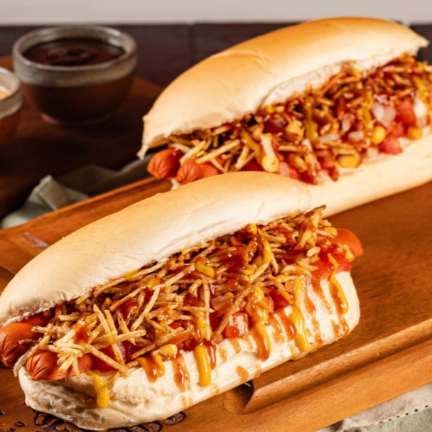 2 x Cachorros quentes tradicional, Pão prensado na chapa, 2 salsichas (PERDIGÂO), salada de tomate e cebola frescas, milho, maionese, batata palha, katchup e mostarda.