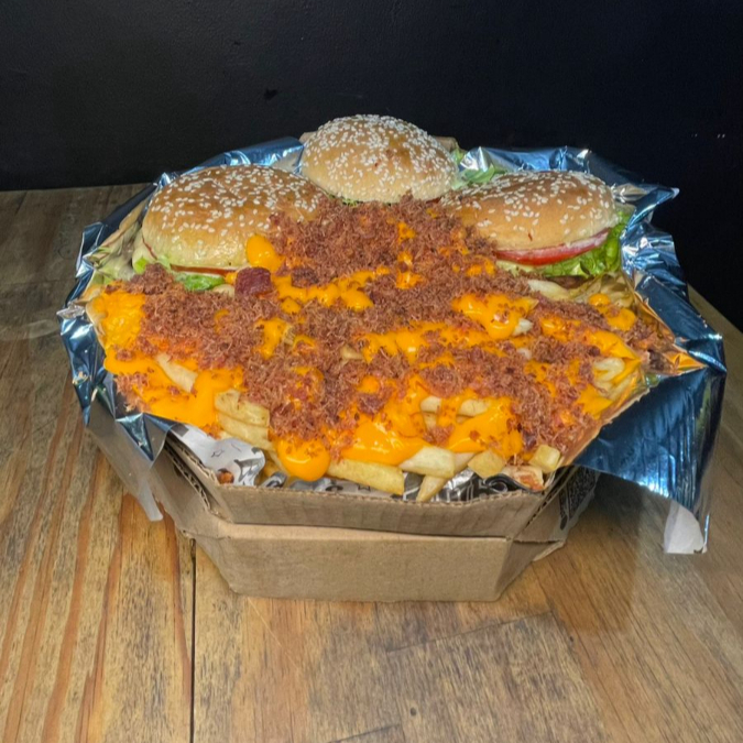 3 hamburgueres, cada um com 1 carne, ovo, queijo derretido no vapor, salada, molho de ervas ( acompanhado de 250g de batata frita com cheddar cremoso e farofa de bacon.