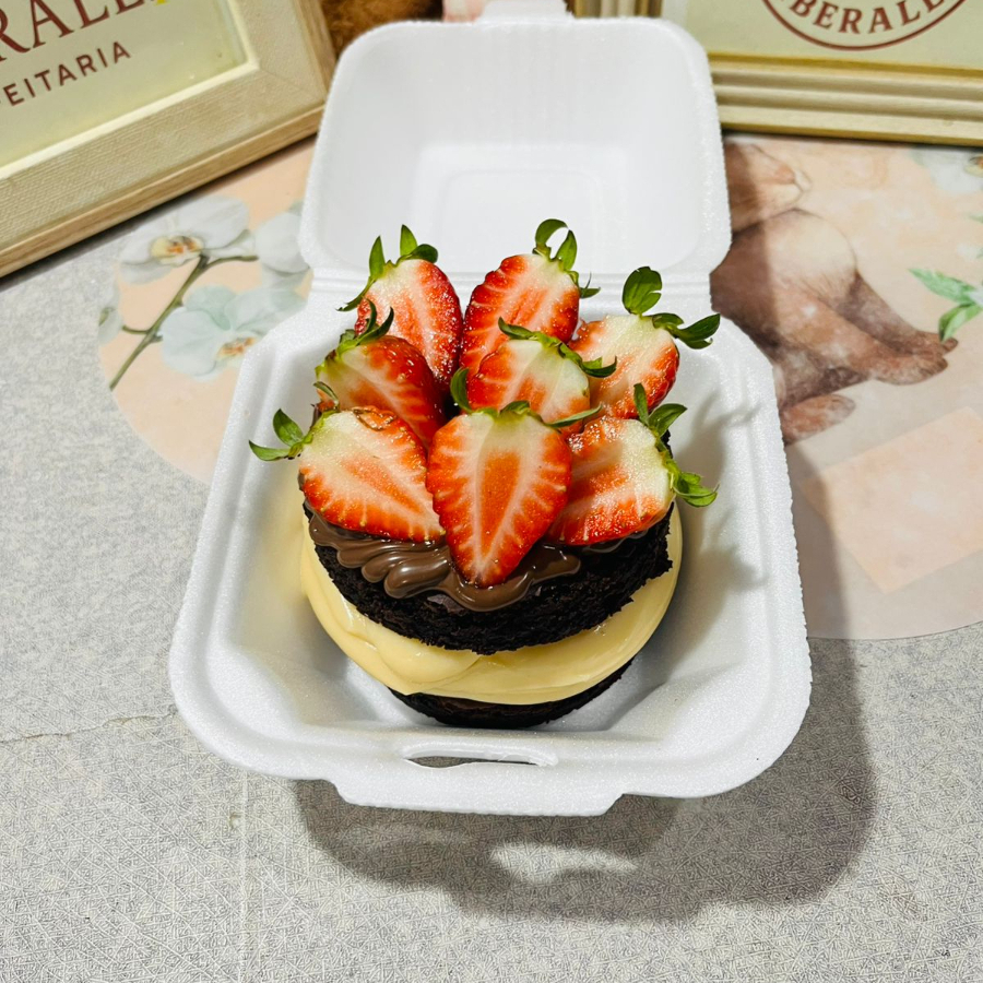 Duas camadas de brownie suculento, com recheio de Ninho ou chocolate, finalizado com Nutella e morangos.