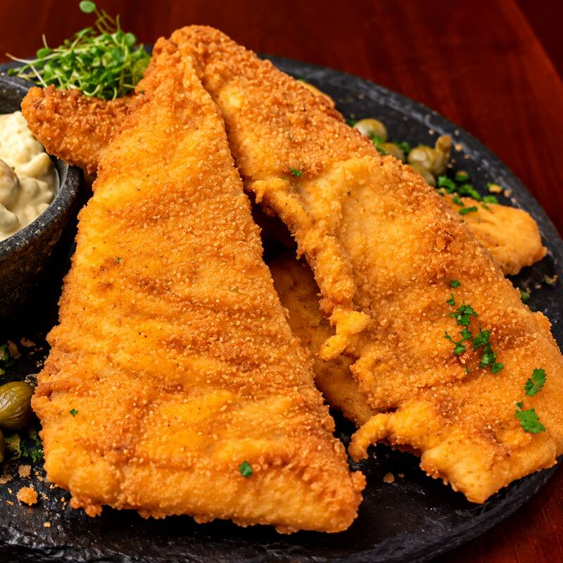 Filé de peixe empanado à milanesa, dourado e crocante, acompanhado de molho tártaro. Uma combinação clássica, saborosa e com contraste cremoso na medida certa.