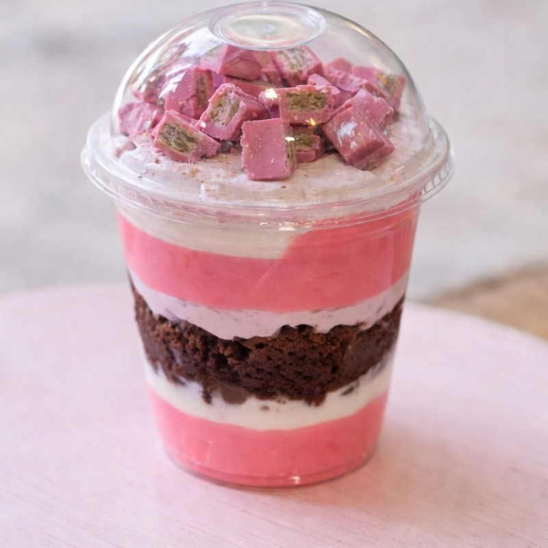 Camadas irresistíveis de creme sabor morango, recheio cremoso, brownie macio e finalizado com deliciosos pedacinhos crocantes de chocolate rosa por cima. Um copo lindo, cremoso e cheio de sabor que conquista já na primeira colherada! 💗🍫