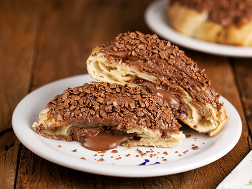 Delicioso Croissant de chocolate com muito recheio de chocolate e coberto com chocolate ao leite com granulado belga.