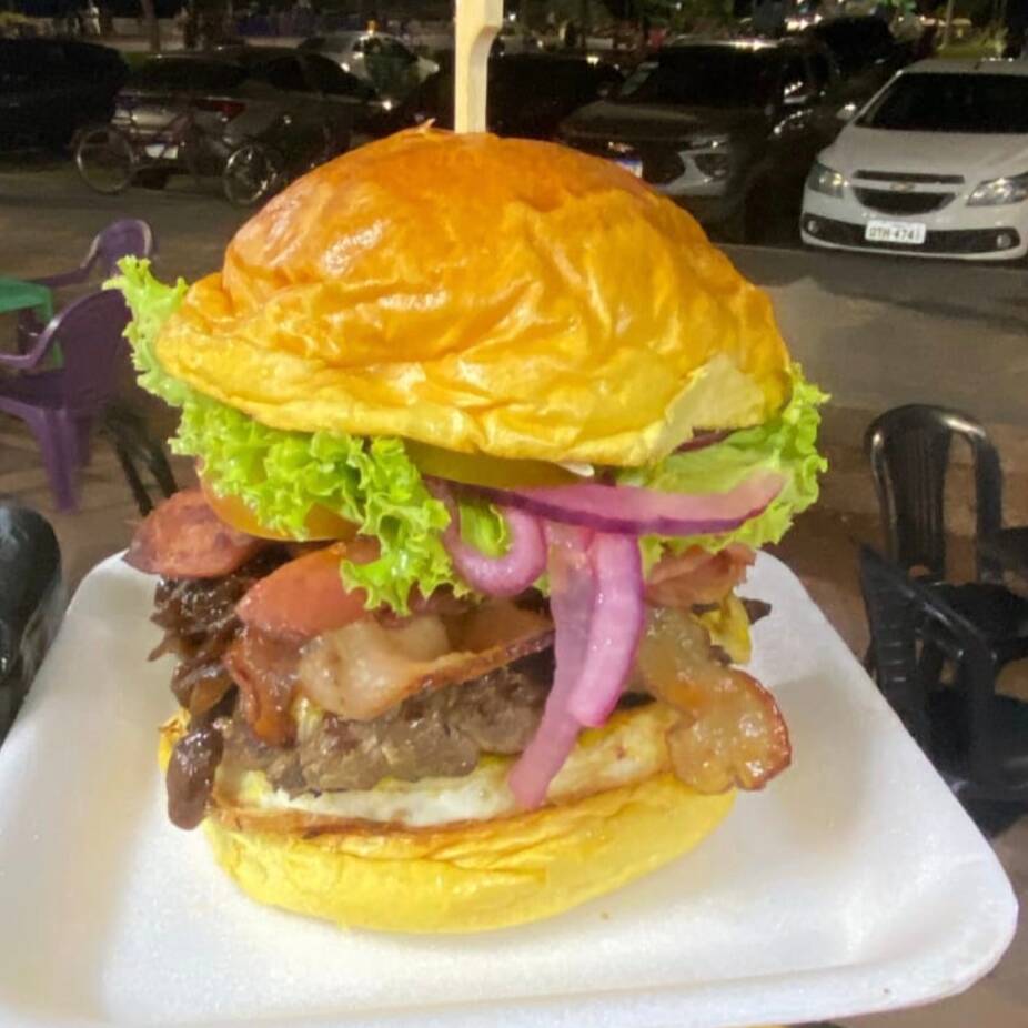 Pão brioche, 3 carnes , ovo , calabresa, bacon, alface , tomate, cebola caramelizada, molho da casa.