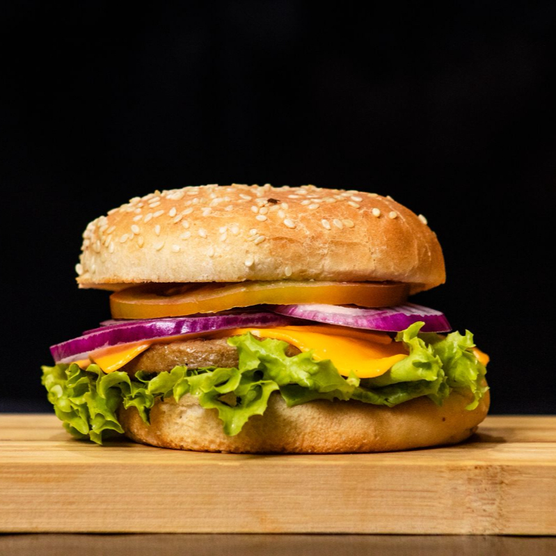 Pão, Carne , Queijo Cheddar, Salada, Tomate, Cebola e Molho da casa.
