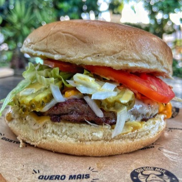 Pão brioche, hambúrguer 140g, mix de queijos cheddar e mussarela, alface, tomate, picles, cebola, maionese temperada da casa e molho mostarda e mel