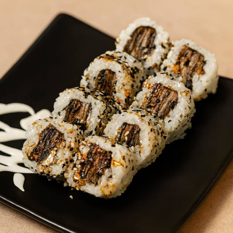 Arroz japonês, alga nori, pele de salmão frita, cream cheese, e gergelim torrado.