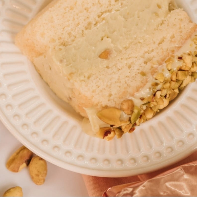 Deliciosa Massa Branca, recheio cremoso de Pistache e Geléia caseira de Frutas Vermelhas in Natura, finalizado com cobertura de Pistache e Pistache Moído.
