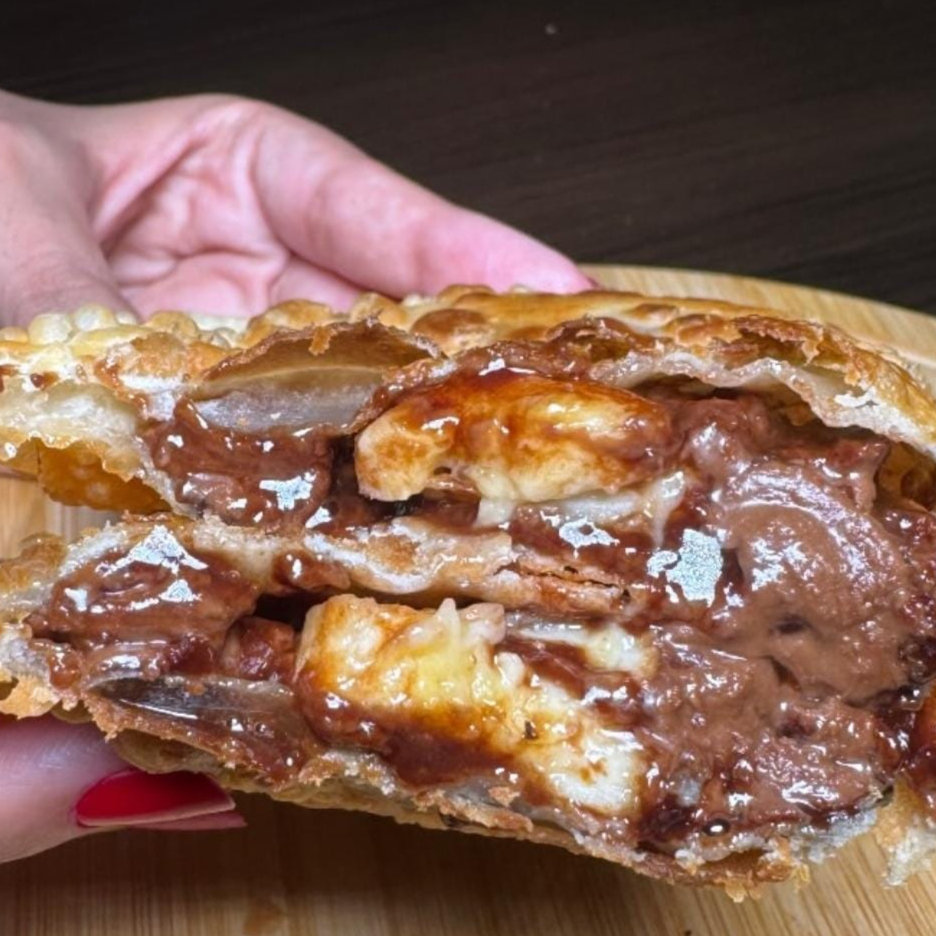 Pastel de Banana com Chocolate Um pastel doce irresistível, recheado com fatias de banana madura e chocolate cremoso, formando a combinação perfeita entre sabor e textura. Crocante por fora e macio por dentro — ideal para quem ama uma sobremesa quentinha e deliciosa.