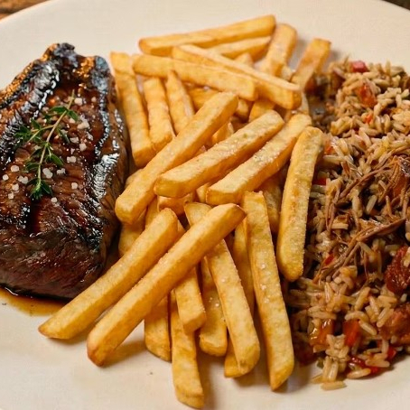 Picanha grelhada servida com arroz texano e batata frita.