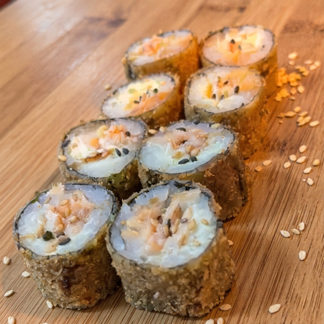 Salmão, cream cheese, alga, arroz, empanado na farinha panko, com tarê artesanal por cima.
