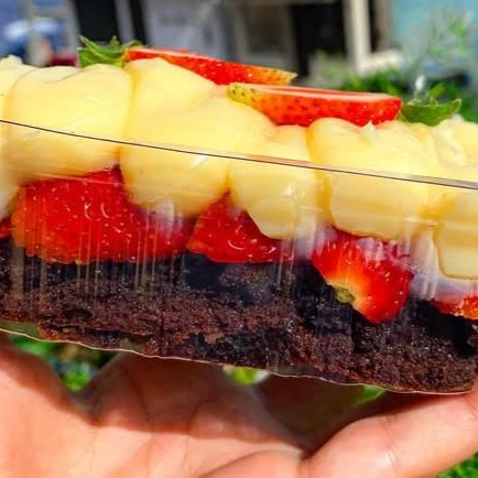 Pedaços de brownie crocante, recheio cremoso de leite ninho e pedaços de morango