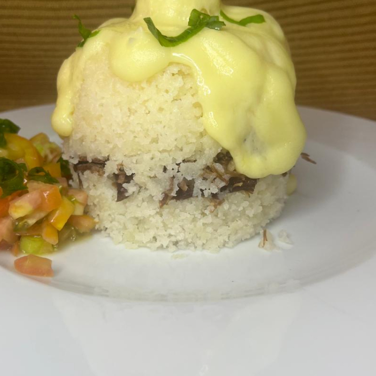 Cuscuz de arroz, carne se sol, queijo e requeijão por cima.