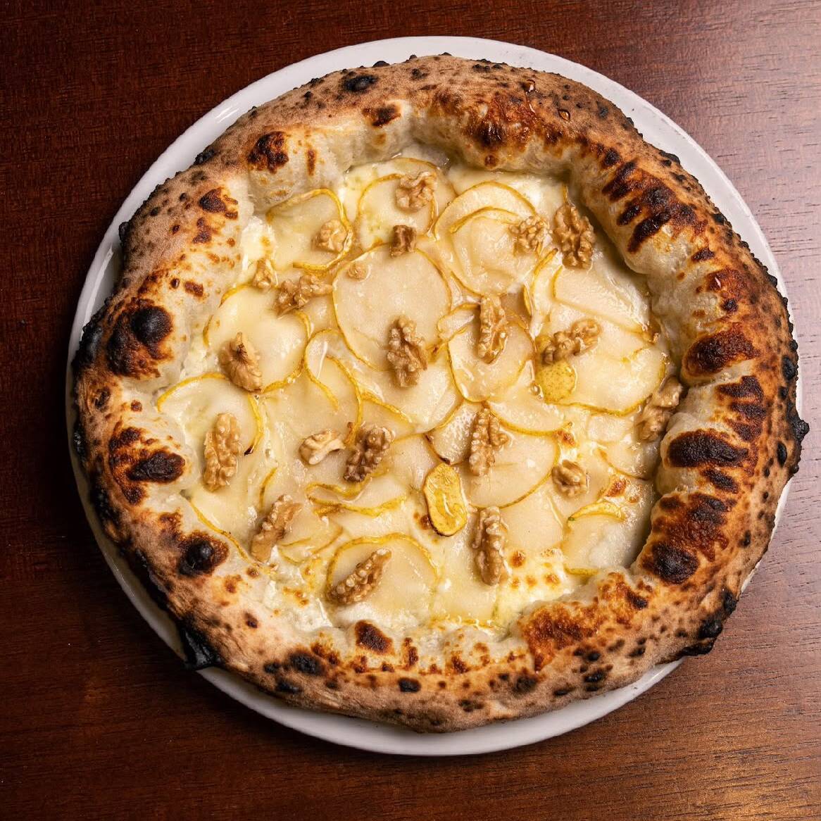 Massa de longa fermentação, creme de gorgonzola, muçarela, pera. Finalizada com mel e nozes.