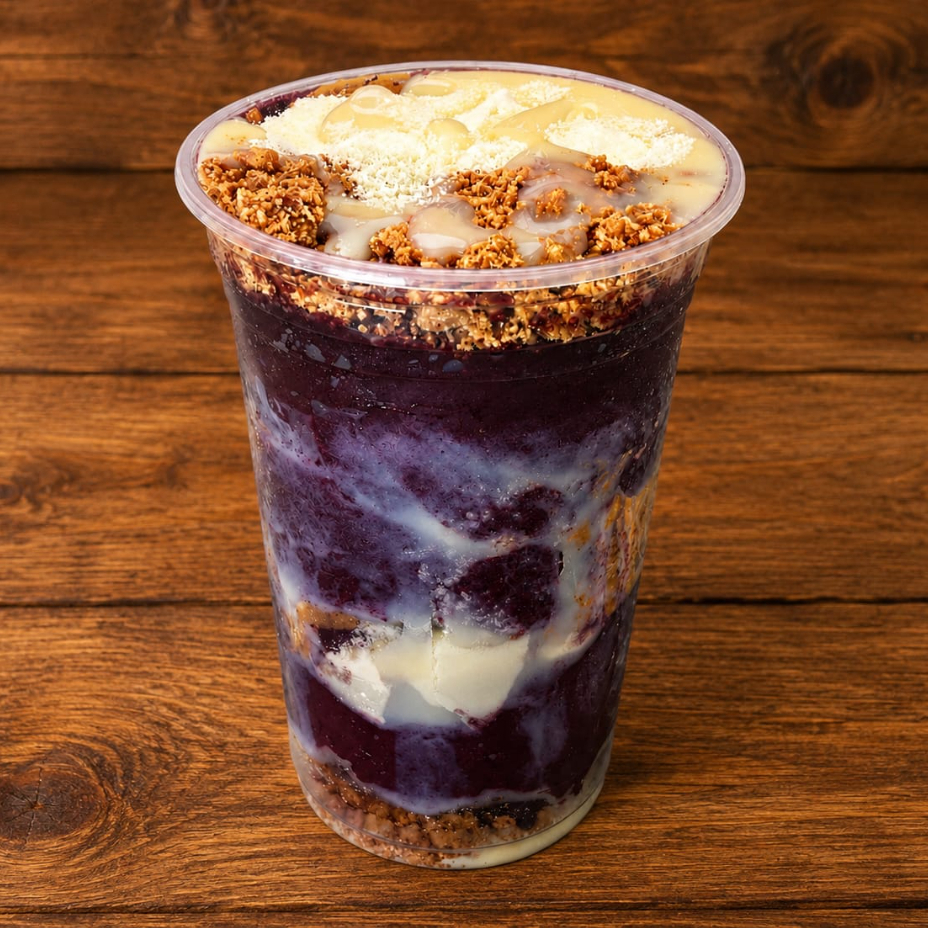 Açaí super cremoso montado em camadas de leite em pó, leite condensado e paçoca