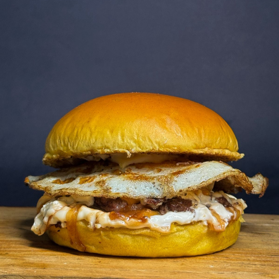 Delicioso Smash de Carne Artesanal de 80g, Pão Brioche, 1 Fatia de Queijo, Ovo, Cebola Caramelizada e Maionese da Casa