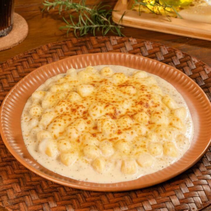 Nhoque de batata com molho cremoso de três queijos.