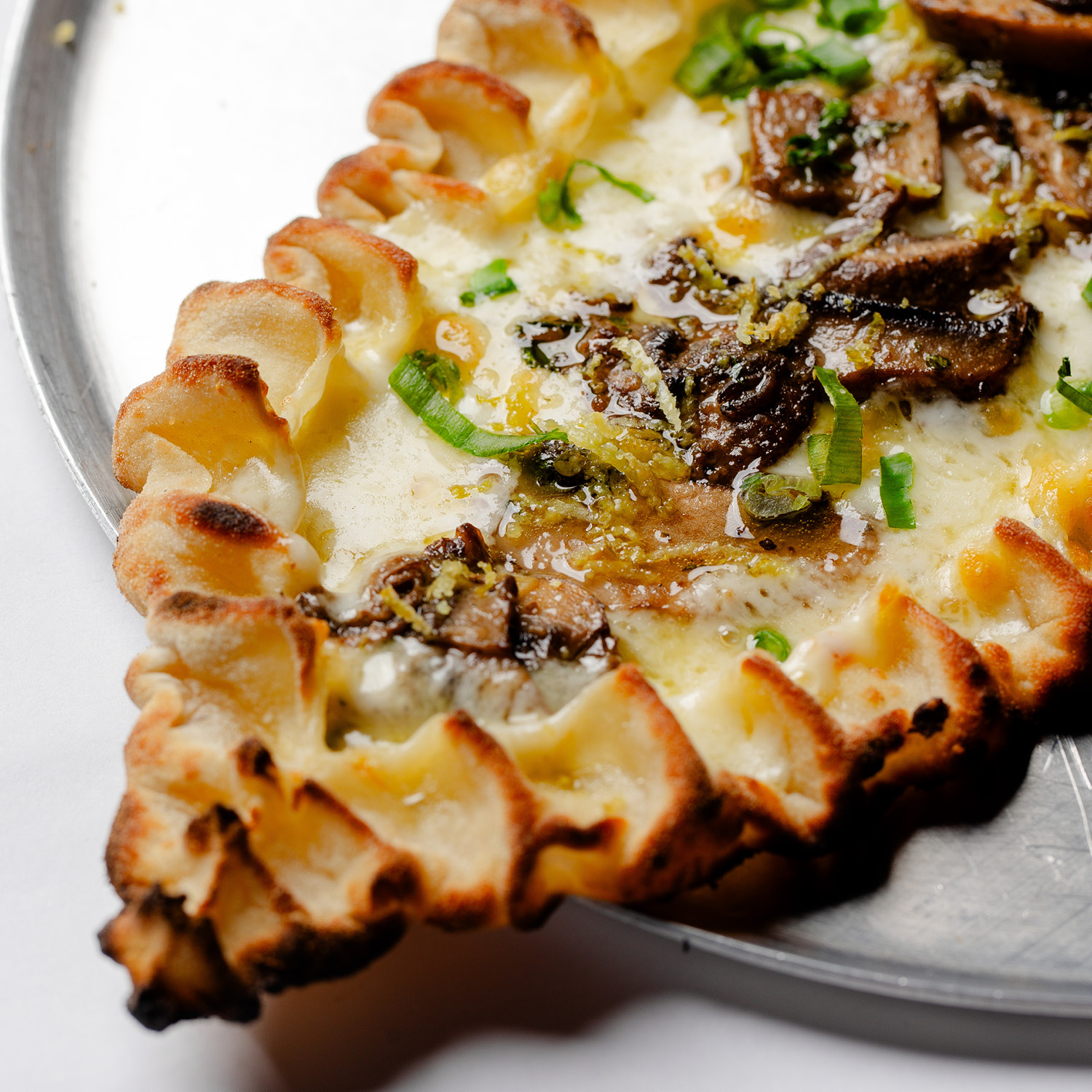 ESFIHA TURCA EM FORMATO DE BARCA, COM MUSSARELA, COGUMELO, CEBOLINHA, PIMENTA DO REINO E RASPAS DE LIMÃO SICILIANO. VEGETARIANA. CONTÉM GLÚTEN. CONTÉM LACTOSE.