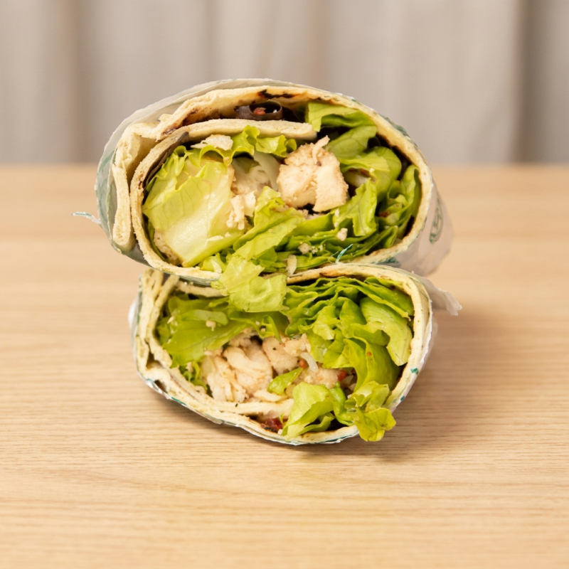 Delicioso wrap montado com mix de folhas, frango desfiado, parmesão ralado e nossa deliciosa farofa de bacon! Acompanha maionese de ervas misturada no wrap!