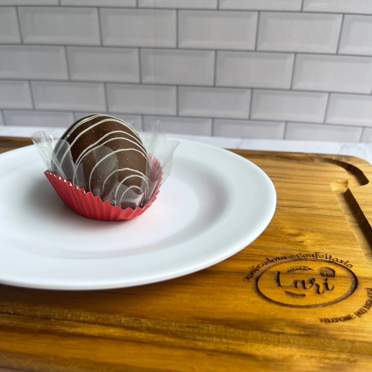 Morango com brigadeiro branco, banhado com chocolate ao leite.