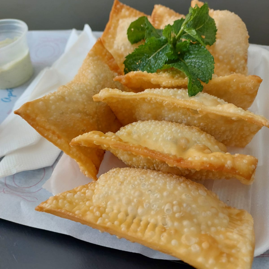Uma porção generosa de mini pastéis, saborosos e crocantes, recheados com carne e queijo.
