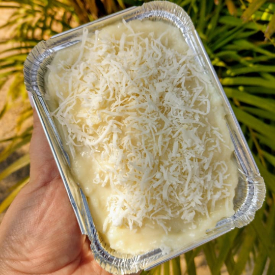 Massa branca molhadinha com leite de coco e leite condensado, cobertura de creme de coco e coco ralado.