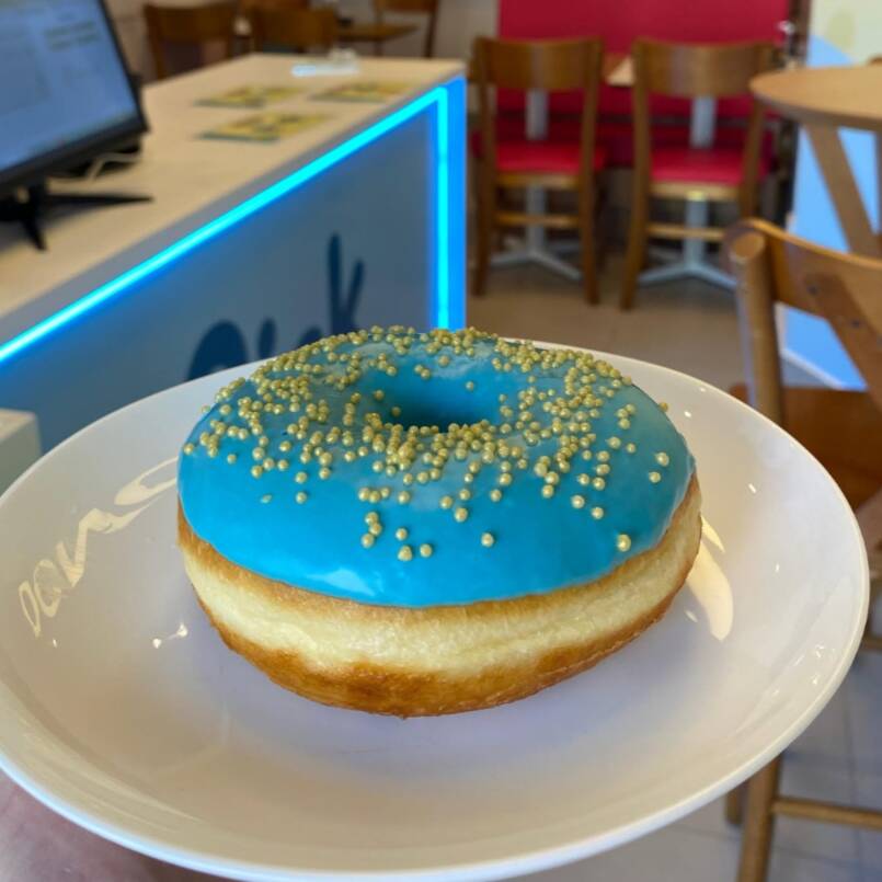 Donut fresquinho e fofinho com cobertura de Chocolate Branco azulado com baunilha.