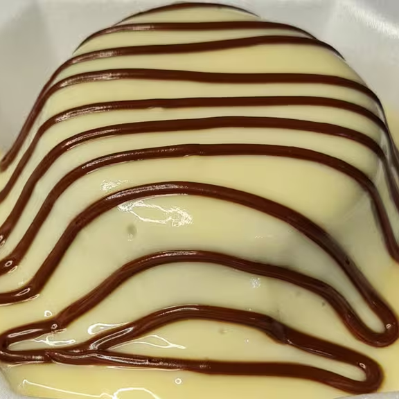 Massa branca com cobertura de brigadeiro de Ninho e creme de avelã.